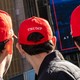 Three men wearing red Trump caps