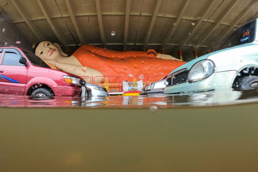 A reclining Buddha statue is surrounded by floodwaters.