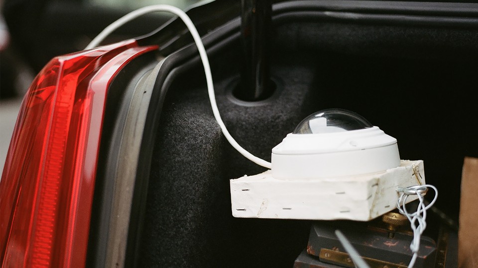 A white surveillance camera in the trunk of a car