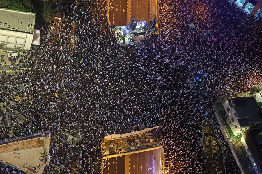 An overhead view of thousands of protesters in a large city intersection.