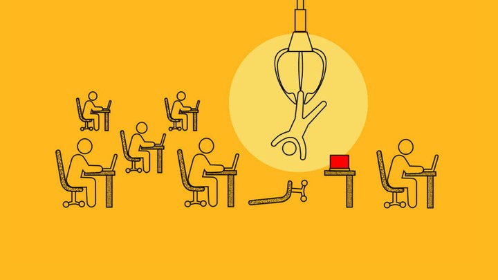 A mechanical claw lifts a person from a desk.