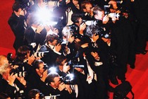 A gaggle of photographers on a red carpet