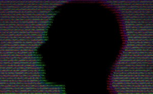 A man's silhouette in front of a background made up of repeating zeroes and ones