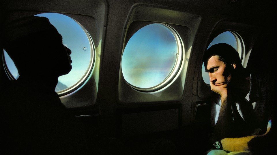 A man sleeping next to porthole windows