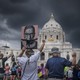 A group of protesters seen from behind raising signs and their fists, in front of the state capitol in St. Paul, Minnesota, in 2022