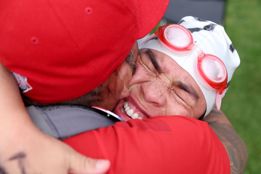 A swimmer embraces someone after a race.