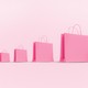 An illustration of pink shopping bags lined up, each one larger than the last.