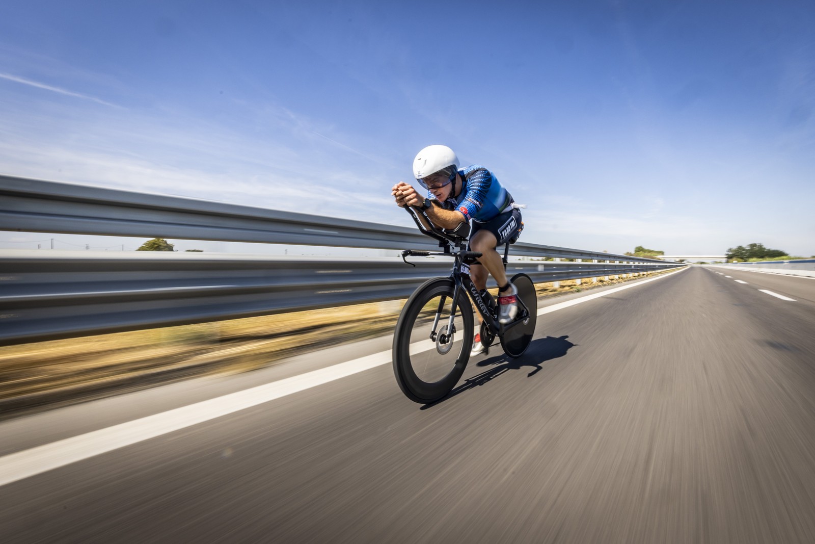An athlete rides a bicycle on a road during a race.