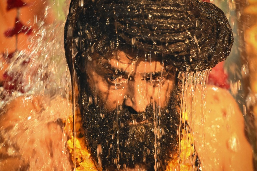Water splashes over the head of a man.