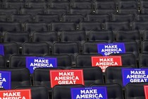 Empty chairs in a venue with “Make America Great Again” signs on them