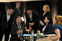 The Roy siblings and executives of Waystar Royco huddled around a phone