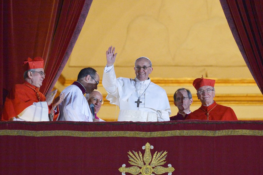 Pope Francis waves from a balcony.