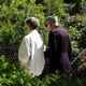 Photo of two people walking arm-in-arm in a park