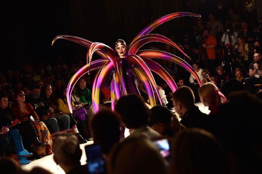 A model walks a runway wearing a very spiky costume.