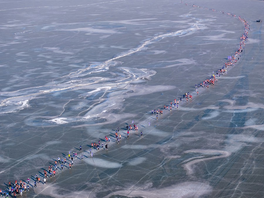 An aerial view of runners competing in a marathon on a frozen lake