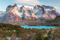 A distant view of a cluster of tall mountains with steep cliffs near their peaks