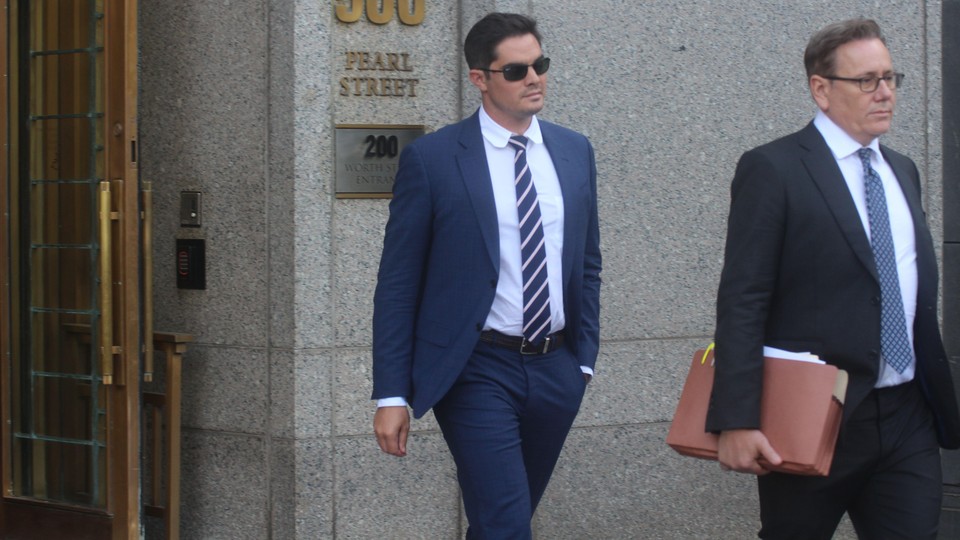 A man in sunglasses and a suit and tie leaves a building marked "500 Pearl Street."