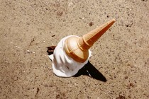 A cone of ice cream melting on the ground