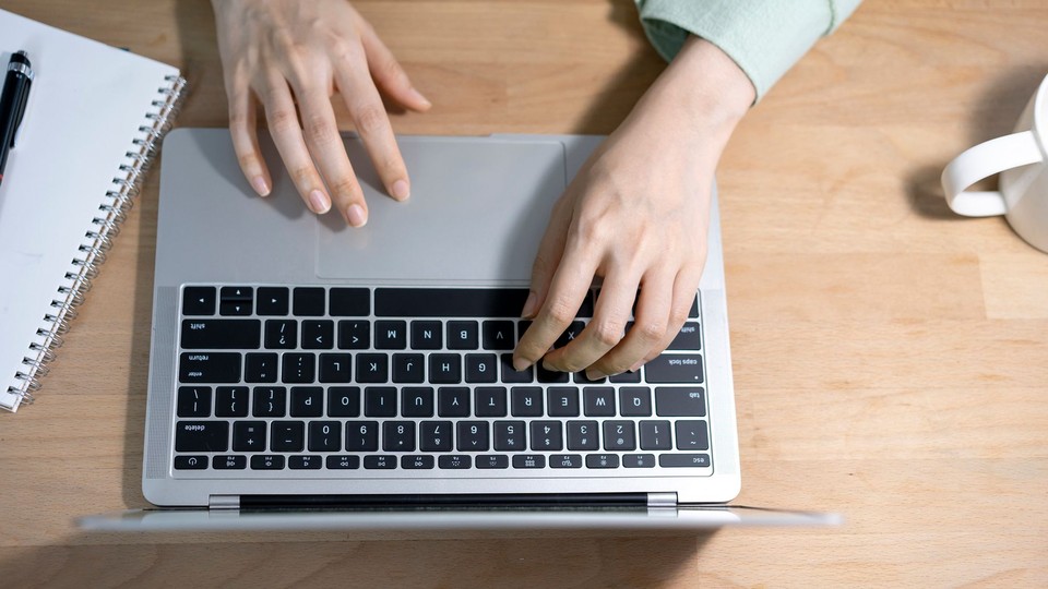 a person's hands on a laptop 