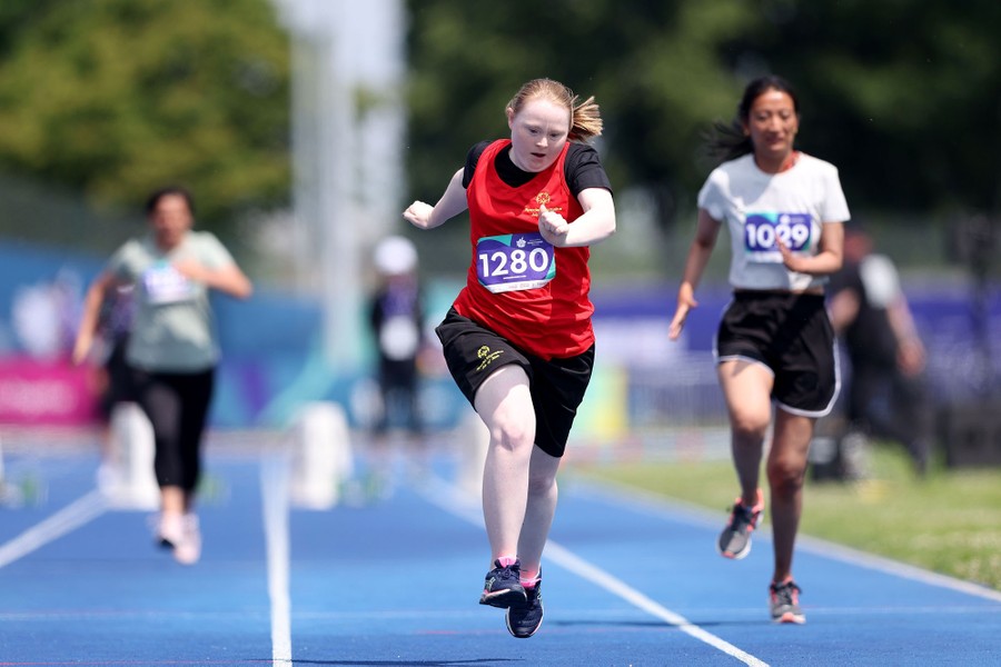 Runners race toward the camera, on a track.