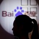 A woman is silhouetted against the Baidu logo
