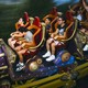 People on Stardust Racers, a purple and blue roller coaster with red chairs at Universal Epic Universe
