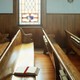 An empty pew with a Bible in a church