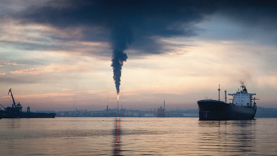 An oil tanker and oil refinery on a cloudy day