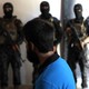 Kurdish soldiers from the Anti-Terrorism Units stand in front a suspected Islamic State member 