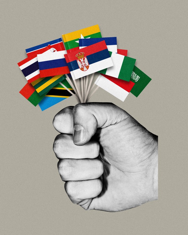 A fist holding several small flags including serbia