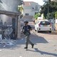 A member of the Israeli forces runs past a fire in Ashkelon following a rocket attack from the Gaza Strip.
