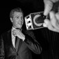 Black-and-white photo of Gavin Newsom in front of a mic held out by a hand