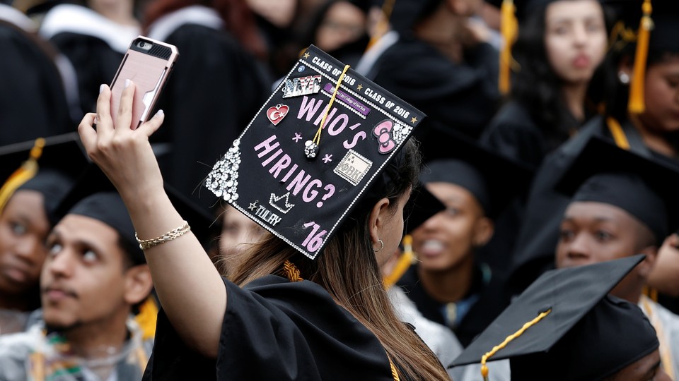 A graduating student's cap reads "Who's hiring?"
