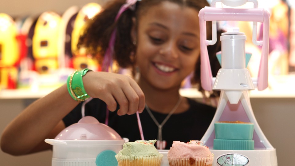 A girl poses with a cupcake-maker toy at the Dream Toys exhibition in London, in 2008.