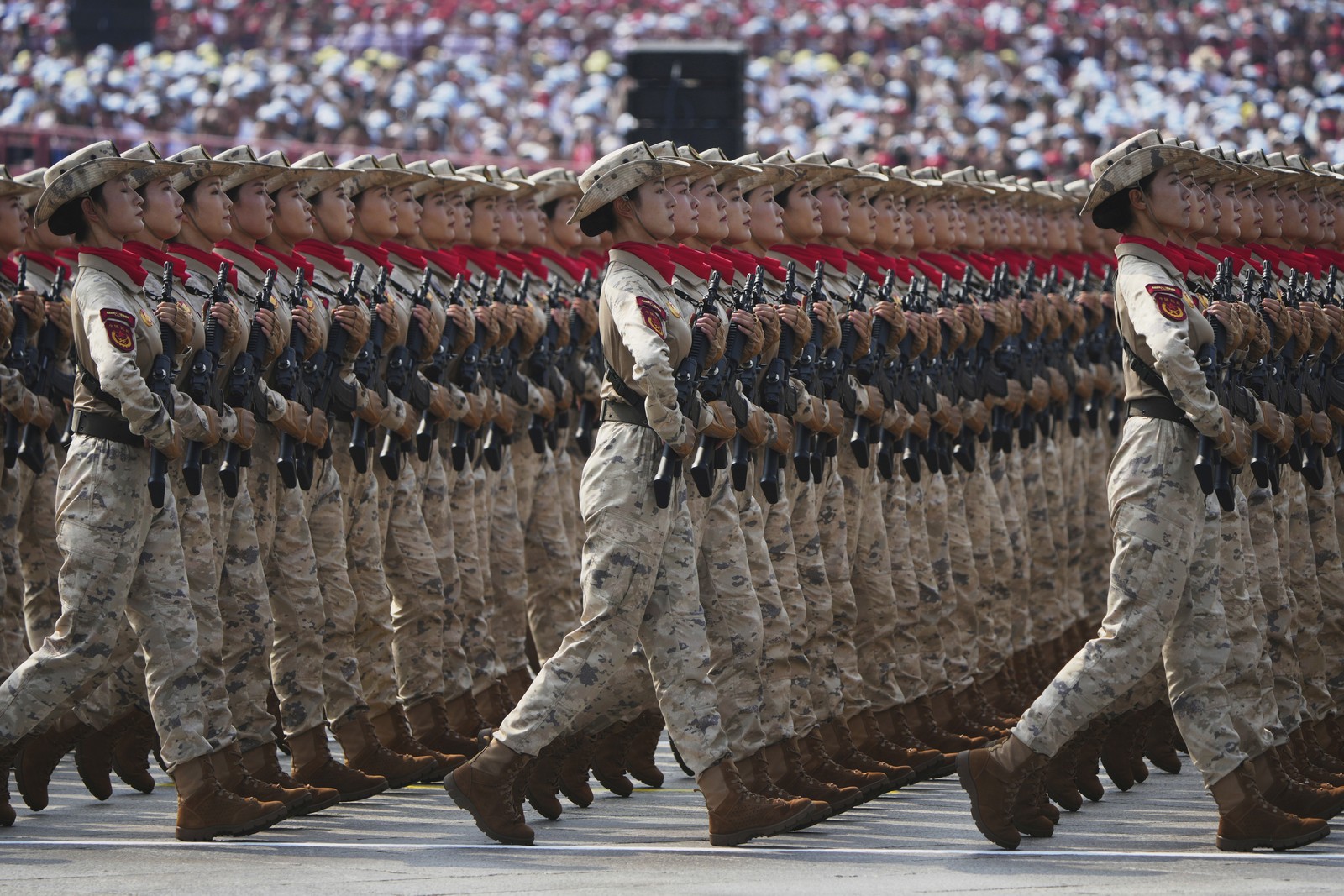 Several lines of soldiers march in unison during a parade.
