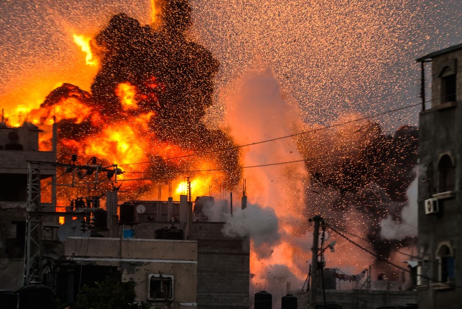 Smoke, sparks, and flames rise over a destroyed building following an Israeli attack on Gaza.