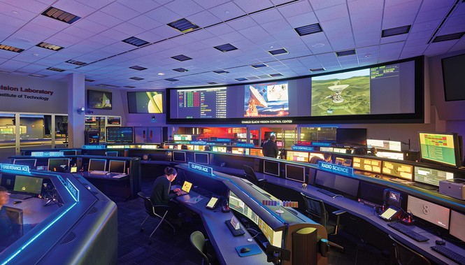 photo of darkened interior room with rows of computer banks and dozens of screens to monitor various missions