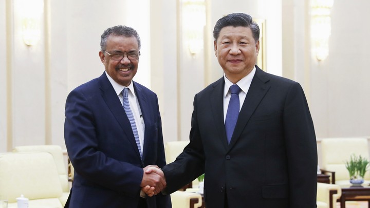 Chinese President Xi Jinping shakes hands with World Health Organization (WHO) Director-General Tedros Adhanom Ghebreyesus.
