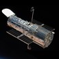 A picture of the Hubble Space Telescope in orbit, shining against the darkness of space