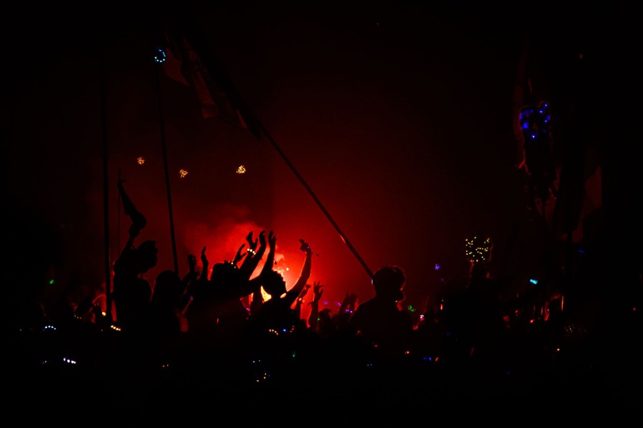 A crowd enjoys a concert, seen in part in silhouette.