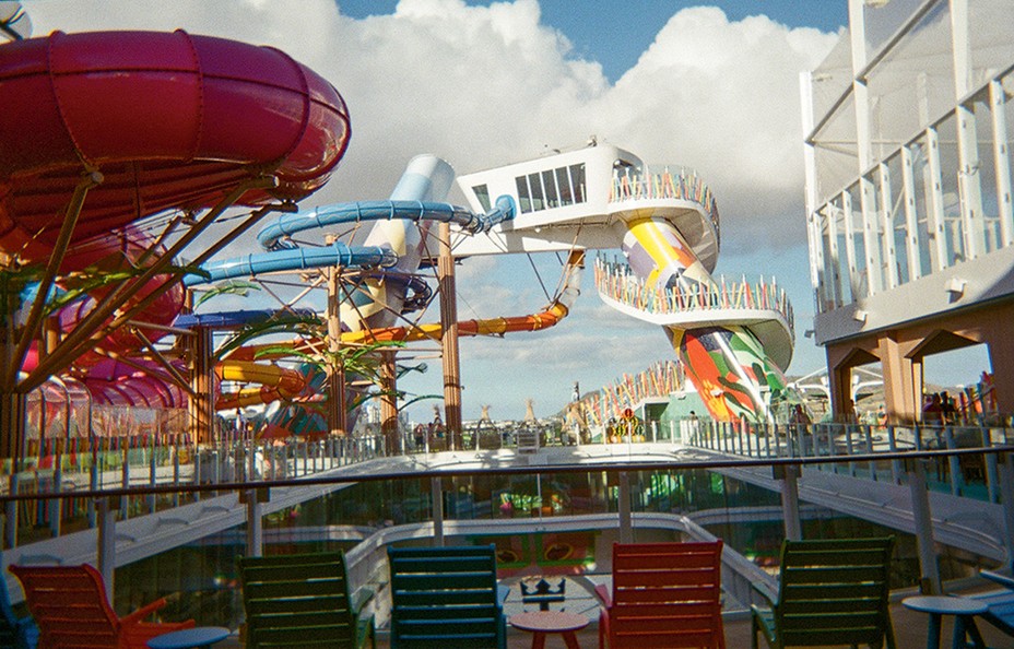 photo of elaborate twisting multicolored waterslides with long stairwell to platform