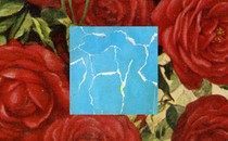 A piece of torn-up blue paper against a backdrop of red roses