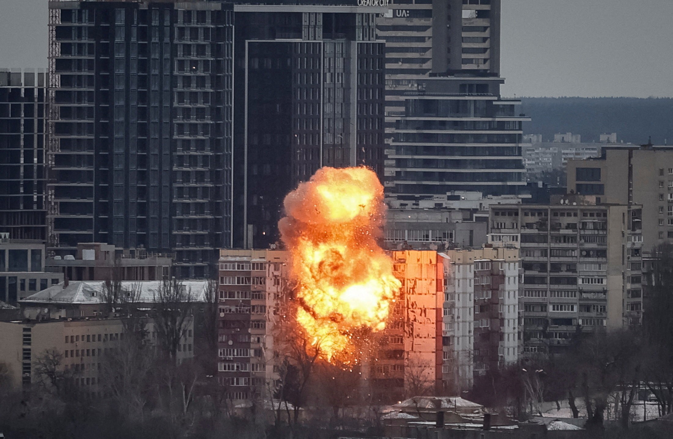 A drone hits an apartment building, sending up a ball of flames and smoke.