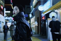 Park Ji-min looking over her shoulder while walking down a street in Seoul in "Return to Seoul"