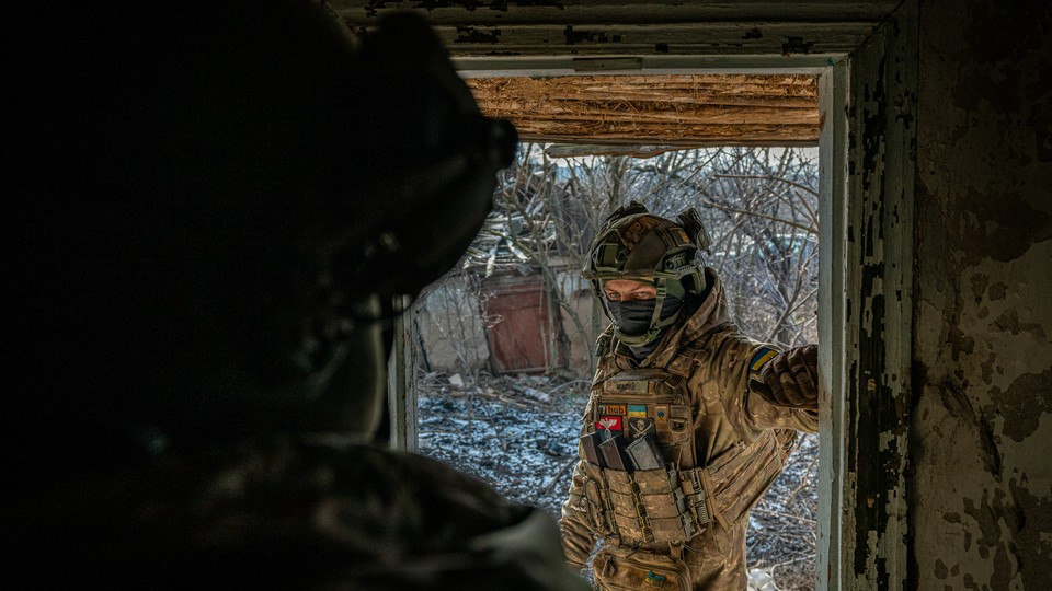 A Ukrainian soldier stands in a doorway