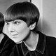 Black-and-white image of Mary Quant in the 1960s with a short bob, reflected sideways in a mirror