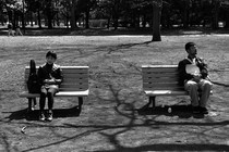 People sitting far apart on benches