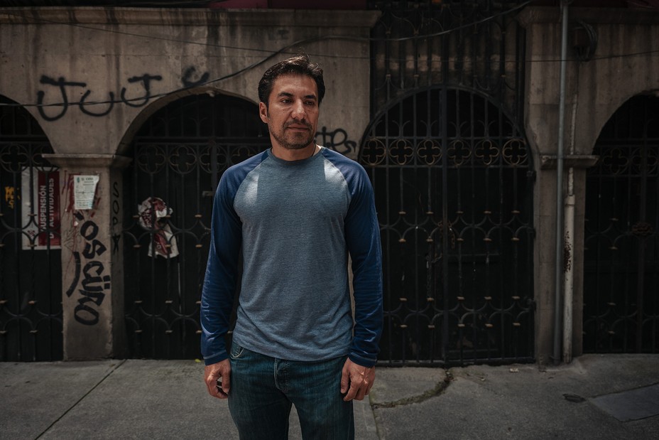 Mauricio Morales, a man with dark hair and a beard appearing to be in his late thirties, stands in a blue shirt