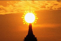 New York City's Empire State Building, with a coronavirus-shaped sun behind it