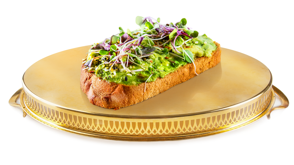 A photo-illustration of avocado toast on top of a golden platter